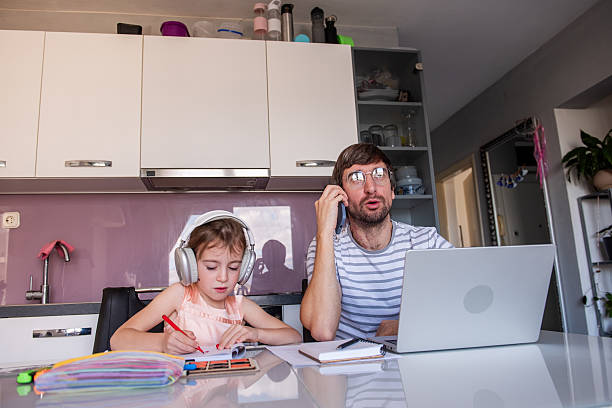 istock Father working from home and having phone call while daughter drawing 2219165133