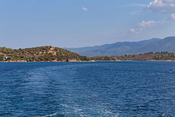 istock A calm blue sea stretches towards a coastline with low hills 2219165202