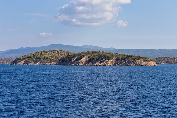 istock A distant island sits in a calm blue sea under a clear sky. 2219165288