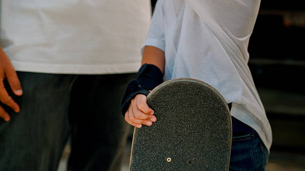 istock Young Asian girl holding a skateboard while her coach was giving her confidence before the competition. 2219166375