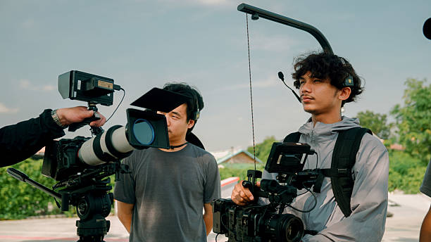 A team of camera crew members talking to each other about how the cameras should be positioned and angled during the junior skateboard competition.