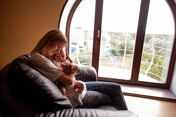 Mother Embracing Baby by a Large Window