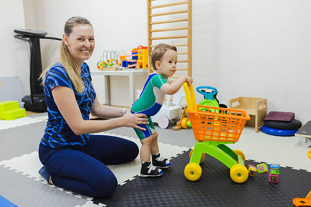 istock Portrait of a physiotherapist helping a child learn to take steps and walk using the center's rehabilitation equipment 2219170695