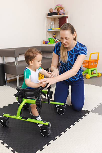 istock Physiotherapist assists young boy with musculoskeletal disorders using mobility aids during rehabilitation exercises in supportive environment 2219170720