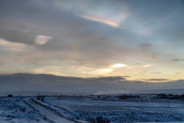 An early morning scene of a snow covered landscape in southern iceland. The sky is filled with stratospheric clouds which refract bright colours.