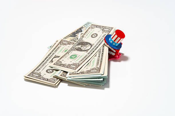 istock An Uncle Sam figurine sits atop a stack of dollar bills, representing financial success. 2219173581