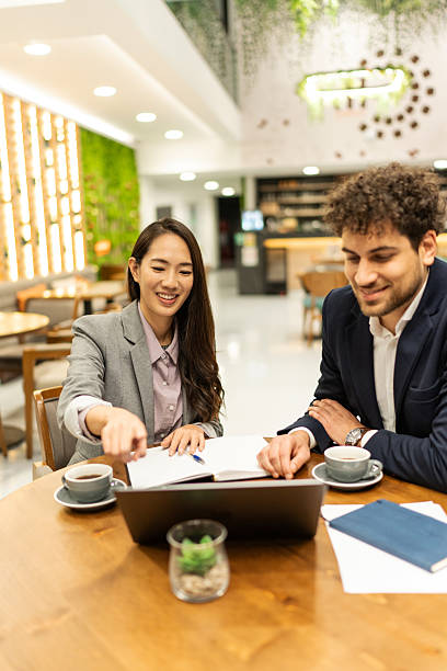 istock Businesspeople collaborating on a project using laptop in a cafe 2219178781