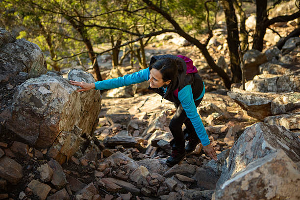 Latin American woman climbing a rocky path on a mountain - Buenos Aires - Argentina