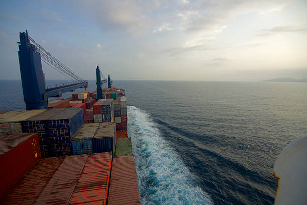 A container ship at sea, view from the bridge wings of the ship with morning sun in the background