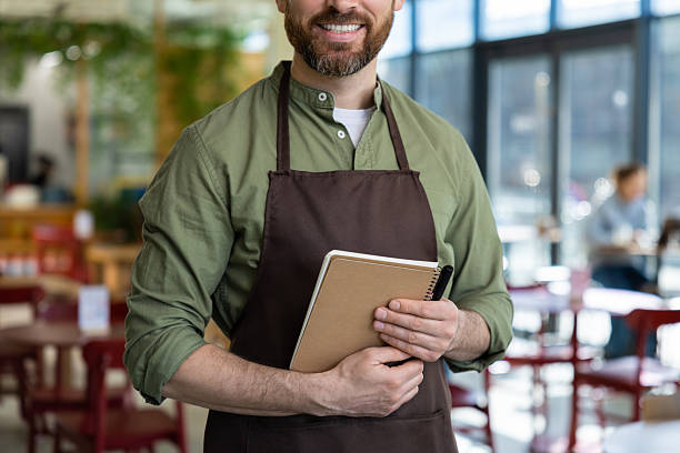 istock Young bearded man in apron looking confident while waiting for the client in pizzeria 2219181971