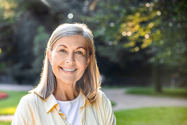 istock Senior woman smiling brightly in park with natural backdrop 2219182431