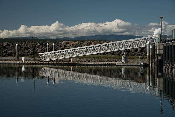 Gangway in Boat Haven connects with its reflection making a beatify symmetric pattern, Olympic mountains range in the background