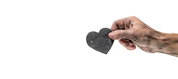 istock Male hand holding black heart on white background with copy space. 2219188765