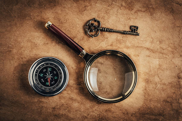 Magnifying glass, key and compass on background old paper. Vintage style.