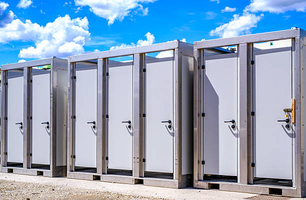 istock Portable restroom facilities lined up in a construction area under a blue sky with scattered clouds during daytime hours 2219192175