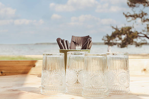 istock Restaurant or camping table with glasses placed on a wooden table facing the sea 2219193449
