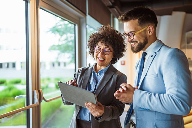 istock male and female colleagues use tablet together and discuss work 2219203871