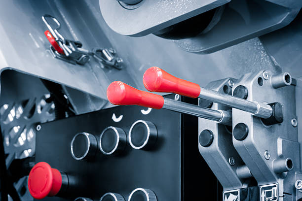 Control panel of modern industrial hydraulic machine with control levers and buttons, industrial concept background.