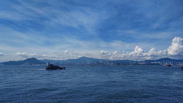 istock Tranquil Seascape with Boat and City Skyline 2219210720