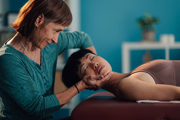 istock Physiotherapist performing craniosacral therapy on patient's head 2219212978