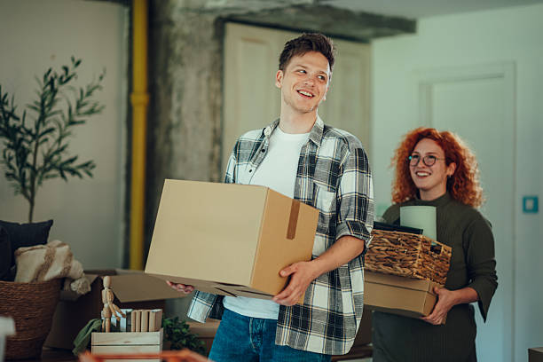 istock Happy couple carrying boxes into new home 2219213977