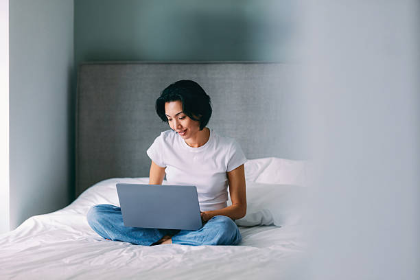 istock Woman Relaxing and Using a Laptop on a Comfortable Bed at Home 2219214147
