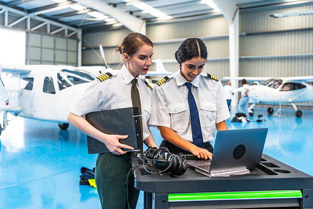istock Female pilots using laptop in hangar with small airplane 2219217241