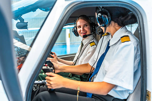 istock Two female pilots smiling and talking while sitting in cockpit of small airplane 2219217257