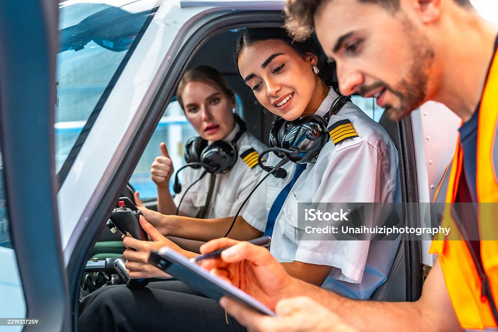 Flight Instructin Flight Instructor Explaining Preflight Checklist To Two Smiling Female ...