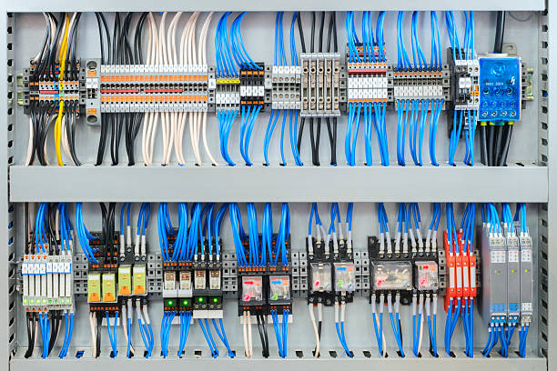 istock Large electrical panel with many wires and switches is blue and white. The panel is filled with various switches and wires, making it a complex and intricate piece of machinery 2219217553