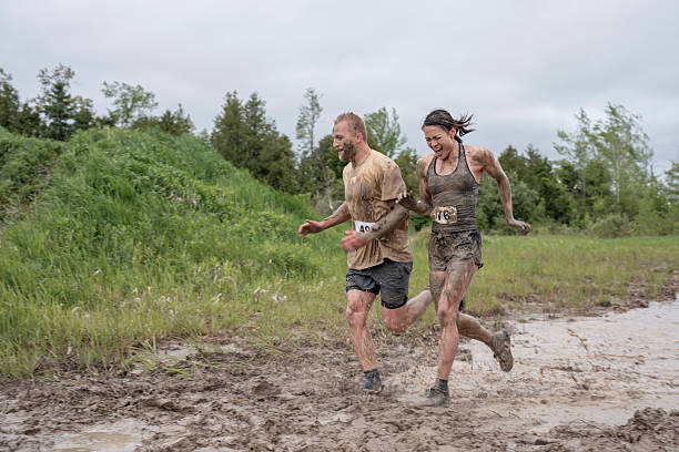 istock Two Athletes Running Through Mud During an Outdoor Obstacle Race 2219219257