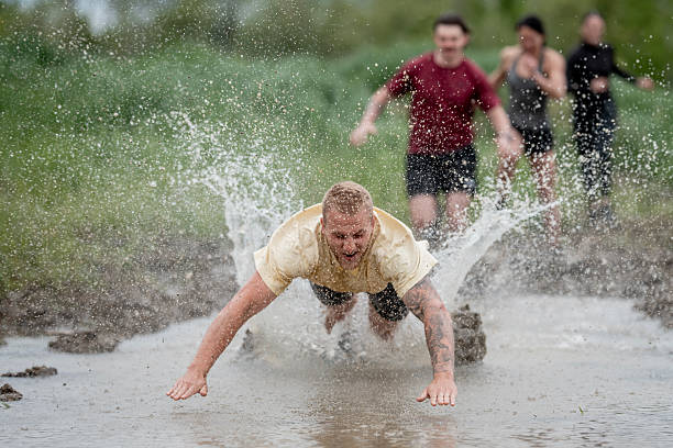 Participants engaged in an exciting mud run, navigating obstacles and making contact with mud and water, capturing fun and energy.