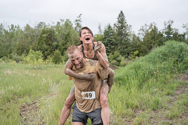istock Joyful Participants Covered in Mud During Outdoor Obstacle Run 2219219923