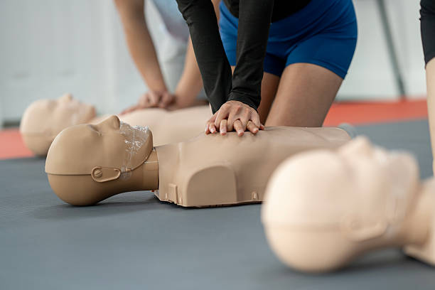 istock CPR and First Aid Training Class with Mannequins in Focus 2219220572