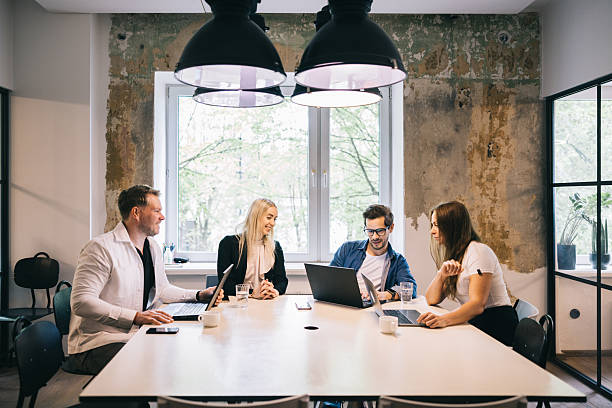 istock Four People Collaborating in a Modern Office Environment with Laptops 2219222044