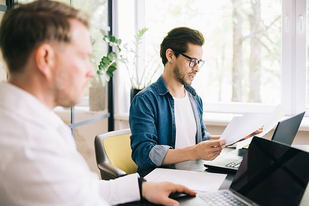 istock Two Businessmen Collaborating in a Modern Office Space 2219222081