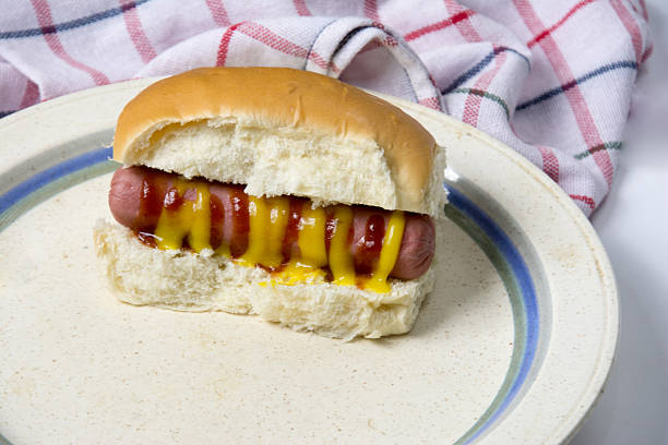 Hot dog with pickled cabbage and carrots, and spicy tomato sauce. Isolate. White background.