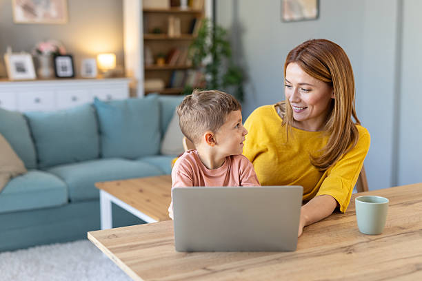 istock Joyful mother and child sharing a moment at home workspace 2219227644