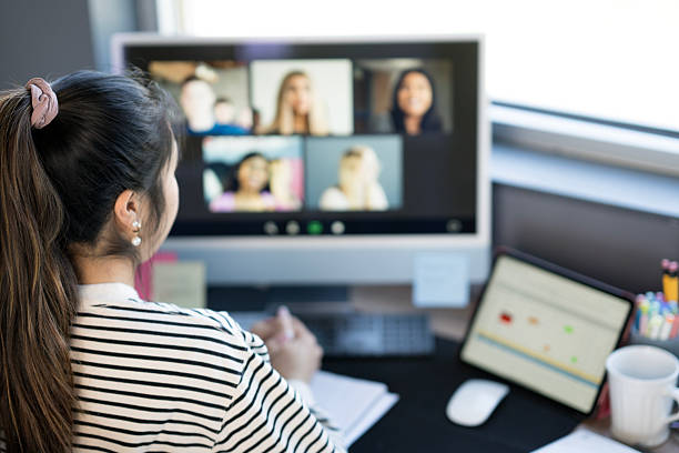 istock Woman Attending Virtual Meeting in Home Office Setting with Modern Equipment 2219227952