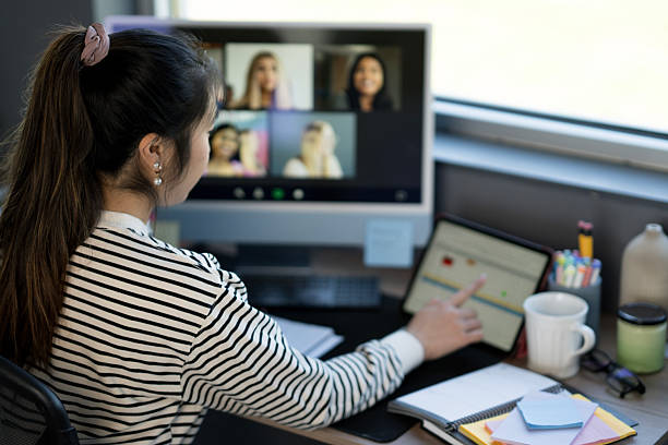 istock Woman Attending Virtual Meeting in Home Office Setting with Modern Equipment 2219227963