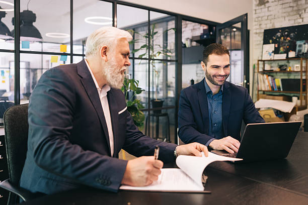 istock Two Businessmen Collaborating in an Office With Documents and a Laptop 2219229716