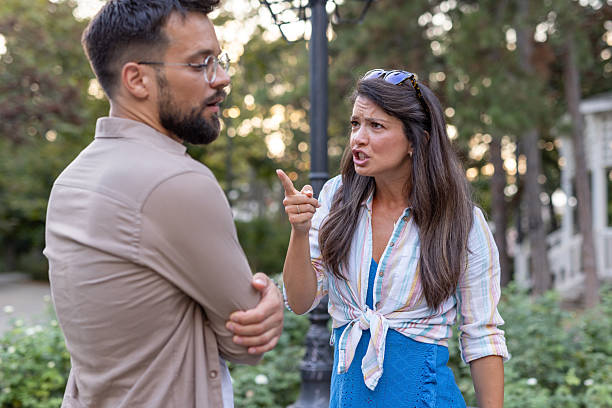 istock Engaged couple in heated conversation standing in park pathway. 2219230555