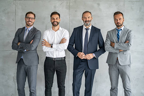 istock Four Professional Men in Stylish Suits Smiling Together 2219230595