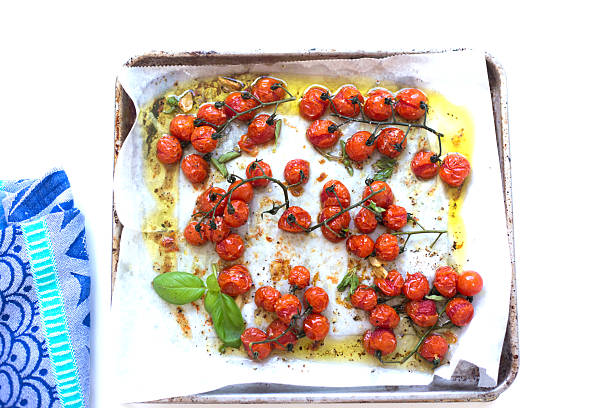 istock Roasted Cherry Tomatoes with Stems on Pan with Parchment, Basil 2219234481
