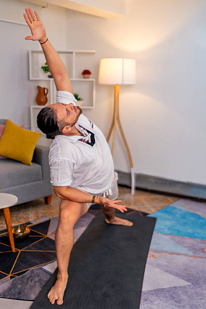 istock Young man practicing yoga at home for stress relief 2219237503