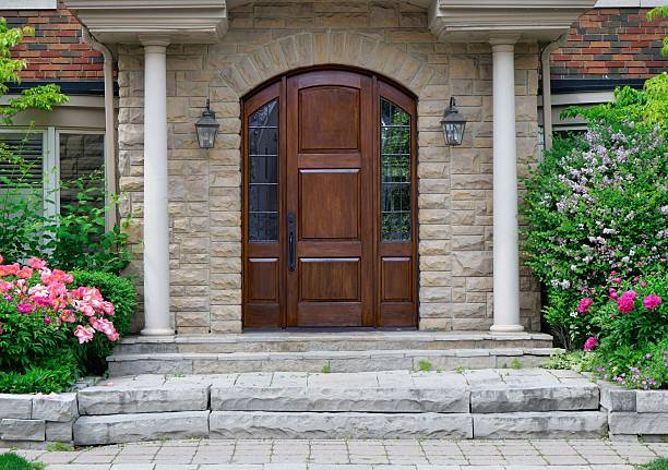 Elegant wood grain front door surrounded by flowers