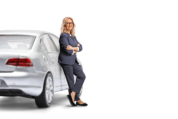 Woman driver leaning on a car isolated on white background