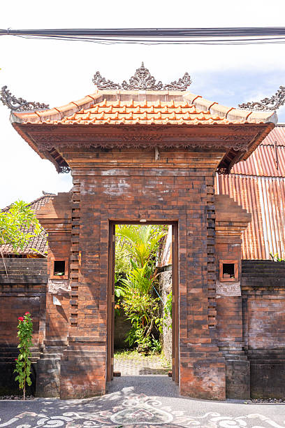 A beautiful Balinese temple featuring intricate carvings, a striking golden door, and cultural details. Highlights the unique artistry and spiritual ambiance of traditional Indonesian architecture.