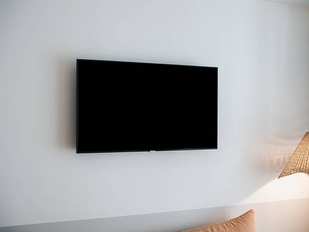 istock Black blank space on LED smart TV with dark empty screen mounted on white wall background in the guest hotel room. Scene of television with rectangle square space display. 2219246315