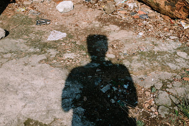 istock Abstract silhouette figure casting dark shadow on urban ground 2219248018